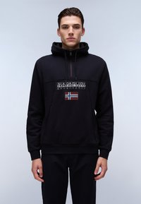 Sudadera negra con cuello con cremalleras, que presenta un parche de logo y una pequeña bandera noruega. Textura suave, corte regular, puños y dobladillo acanalados.