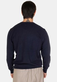 Maglione lavorato a maglia blu navy con maniche lunghe e scollatura rotonda, caratterizzato da una texture liscia e da polsini e orlo a coste.