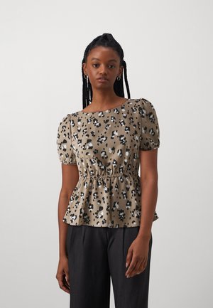 Beige kangaspäinen peplum-toppi, jossa on musta-valkoinen eläinkuos, lyhyet puffihihat ja kerätty vyötärö.