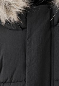 Giubbotto puffa nero con una morbida pelliccia grigia chiaro sul cappuccio, caratterizzato da un tessuto liscio e dettagli verticali cuciti.