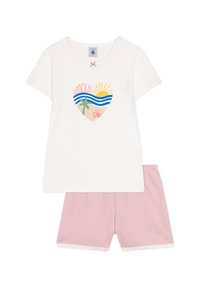 T-shirt bianca a maniche corte con una grafica a forma di cuore che presenta onde, una palma e un sole. Abbinata a pantaloni corti a righe rosa.