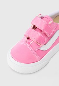 Ροζ πάνινο αθλητικό παπούτσι με λευκή λαστιχένια σόλα, διαθέτει δύο λουράκια με αυτοκόλλητο και ραφές. Στρογγυλεμένη μύτη και υφή στη σόλα.