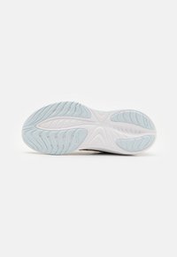 Suola delle scarpe realizzata in materiale gommoso bianco testurizzato, con una design blu chiaro e scanalature per la trazione. Marchi del brand visibili.