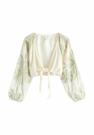 Cremefarbene, kurz geschnittene Bluse mit langen Ballonärmeln, grüner Blumenstickerei und vorderer Schlaufenbindung.