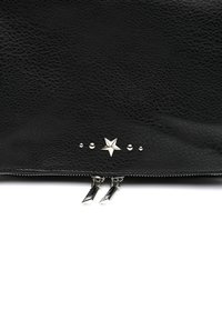 Pochette en cuir noir avec une surface texturée, accent étoile argentée, rivets et fermetures éclair doubles avec tirants pointus.