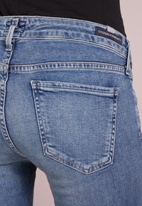 Ljust blå denimjeans med slim fit, med en bakficka och kontrasterande sömmar. Midjan har en märkesetikett.