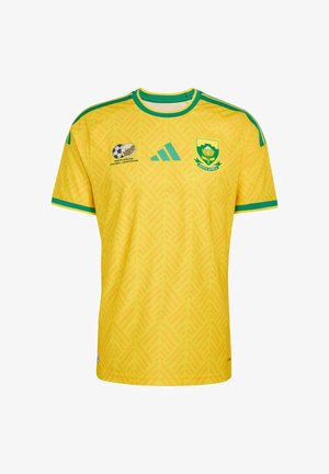 Geel Zuid-Afrikaans voetbalshirt met groene bies, Adidas-logo, embleem van de Zuid-Afrikaanse voetbalbond en het nationale teamwapen op de borst.