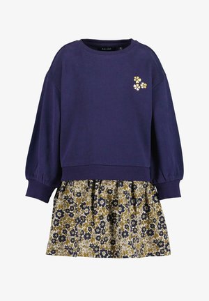 Fioletowa bluza z elastycznymi mankietami oraz spódnica w kwiatowy wzór w kolorach żółtym, niebieskim i białym. Na piersi zdobiona złotym haftem kwiatowym.