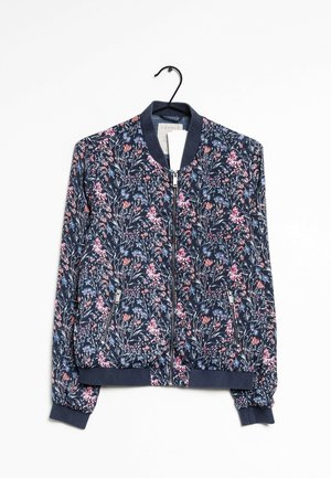 Marineblaue Bomberjacke mit pinkem, rotem und blauem Blumenmuster, durchgehendem Reißverschluss, Reißverschlusstaschen sowie Rippstrickbündchen und -kragen an einem schwarzen Kleiderbügel.