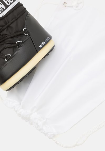 Black Moon Boot with a smooth finish, lace-up design, and a cream-colored sole. Accompanied by a white fabric drawstring bag.
