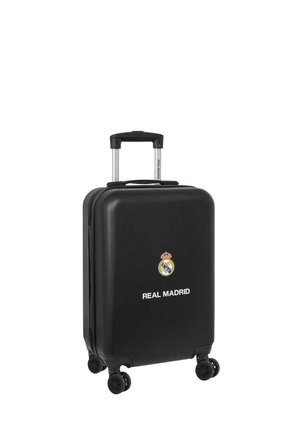Valigia rigida nera con manico telescopico e quattro ruote. Presenta il logo del Real Madrid e testo bianco. Superficie testurizzata.