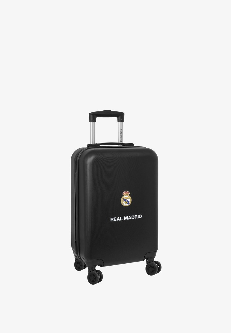 Valigia rigida nera con manico telescopico e quattro ruote. Presenta il logo del Real Madrid e testo bianco. Superficie testurizzata.