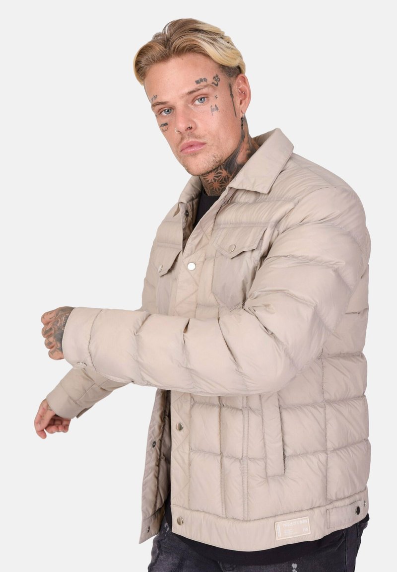 Lyse beige pufferjakke med quiltet mønster, trykknapper og bøjet krave. Har en afslappet pasform og blød, glat tekstur.