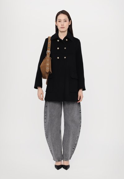 Black wool coat with gold buttons, large front pockets, paired with gray oversized jeans and black pointed-toe heels. Brown shoulder bag.