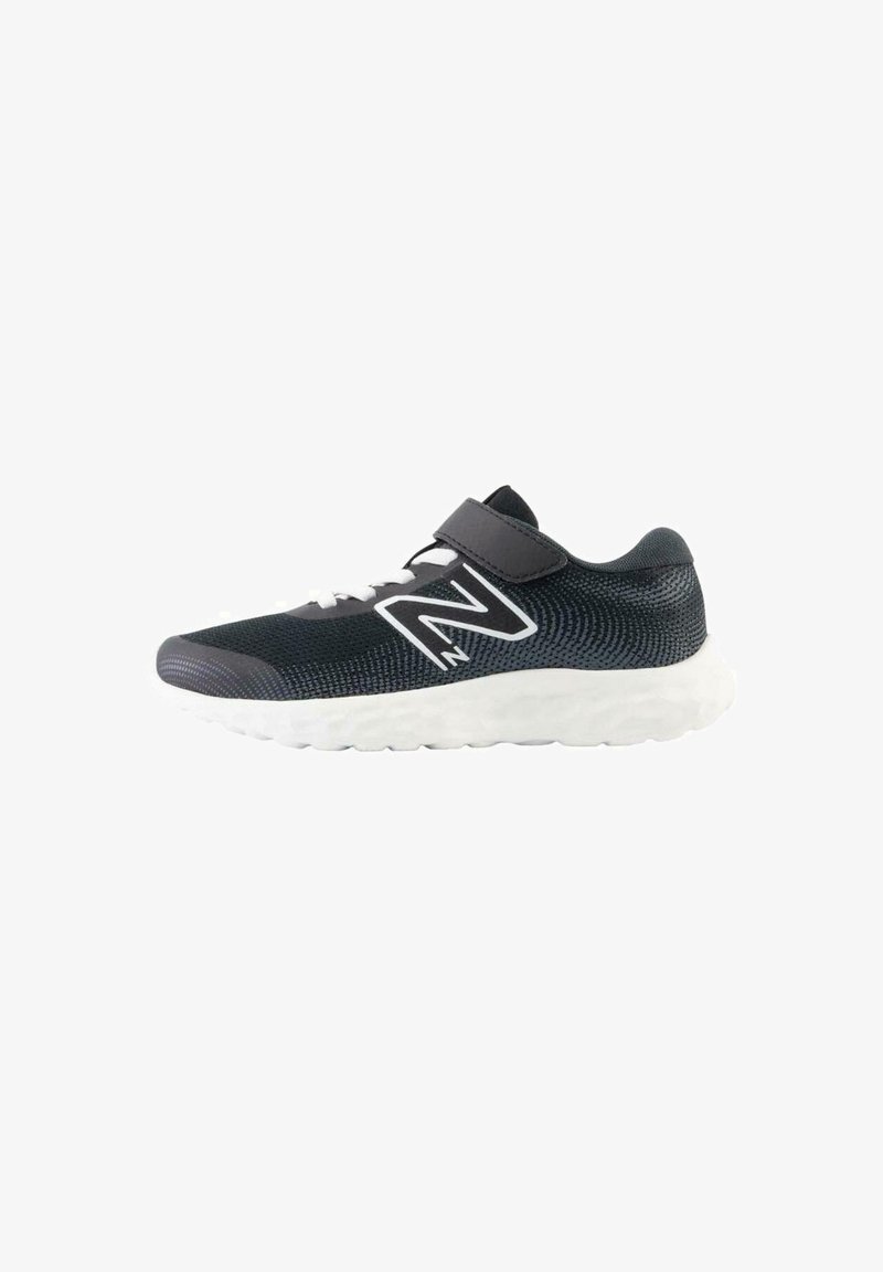 Zapatillas deportivas para niños con una parte superior de malla negra, acentos blancos, una correa con cierre de gancho y bucle, y una suela blanca texturizada.