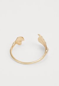 Pulsera de brazalete de oro con un diseño suave y curvado, adornada con acentos decorativos en forma de hoja en ambos extremos. Superficie simple y texturizada.