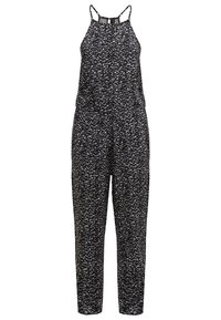 Combinaison sans manches tachetée noir et blanc avec col halter et jambes fuselées, coupe décontractée.