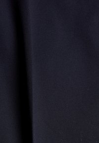 Tejido de un oscuro color navy con una textura suave y un ligero brillo, que presenta patrones de tejido diagonal y sutiles arrugas. Ideal para sastrería o tapicería.
