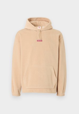 Beige színű bolyhos kapucnis pulóver, elülső kenguruzsebbel. A mellkasán piros "LEVI'S" logó található, az ujjakon pedig elasztikus mandzsetta.