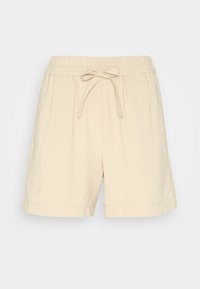 Pantaloni corti in cotone beige con un elastico in vita e un nastro anteriore. Presentano una vestibilità rilassata e bordi rifiniti. Texture liscia, senza motivi particolari.