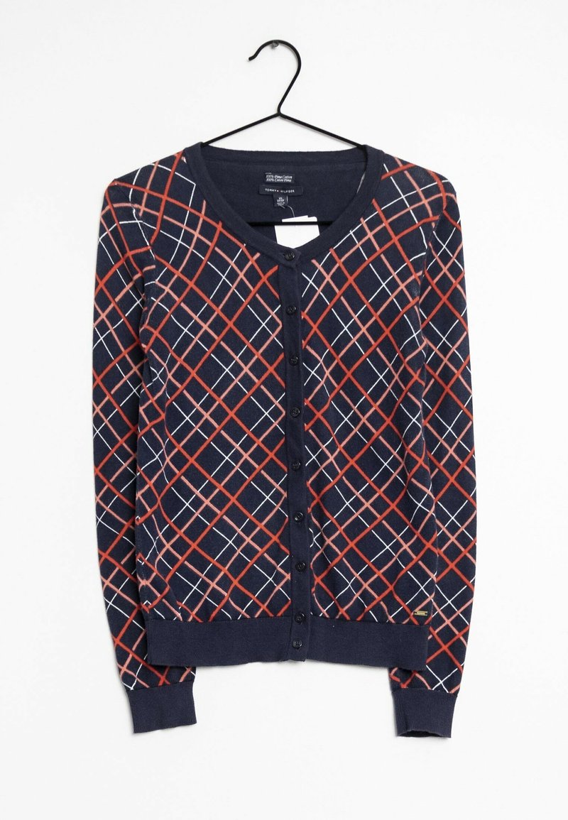 Granatowy kardigan z czerwono-białym geometrycznym wzorem, z guzikami z przodu, ściągaczami na mankietach i u dołu, wykonany z miękkiego materiału tekstylnego.