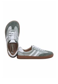 Paire de baskets basses gris et blanc avec semelles marron, lacets blancs et bandes blanches décoratives sur les côtés.