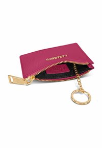 Portafoglio in pelle fucsia con zip e accessori in oro, dotato di un portachiavi a catena e rivestimento interno nero. Nome del brand impresso sul davanti.