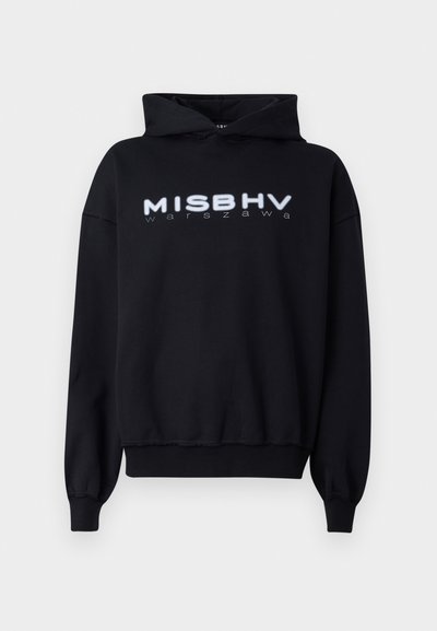 Black hooded sweatshirt featuring the text "MISBHV warszawa" in white, with a relaxed fit and ribbed cuffs and hem. Soft fabric texture.
