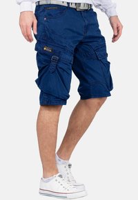 Shorts cargo bleu marine en coton, dotés de plusieurs poches, passants de ceinture et d'une coupe décontractée avec un ourlet retourné. Design décontracté.