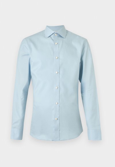 Ανδρικό πουκάμισο με μακριά μανίκια σε ανοιχτό μπλε χρώμα, με λευκά κουμπιά και μυτερό γιακά, εμφανίζεται σε μονόχρωμο φόντο.