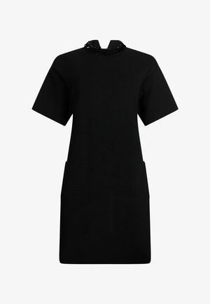 Crna haljina s kratkim rukavima, visokim ovratnikom koji sadrži ukrase i dva bočna džepa. Napravjena od glatkog materijala sa strukturiranim oblikom.