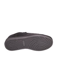 Suola di scarpa in gomma nera con una superficie texturizzata caratterizzata da motivi arrotondati e scanalature per una migliore aderenza, che si abbinano a un design superiore liscio.