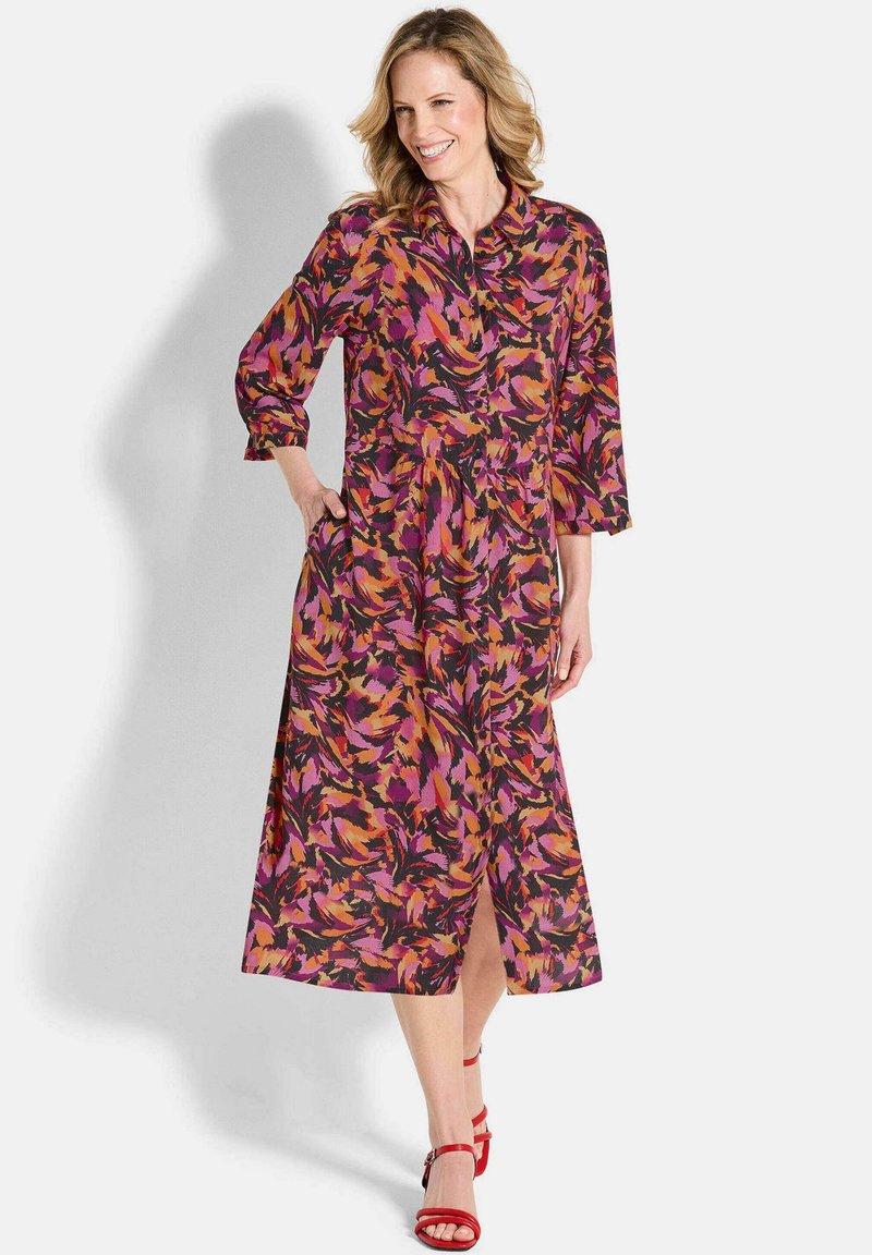Bedrucktes Midi-Kleid in einer Kombination aus Pink, Orange und Schwarz, mit langen Ärmeln, einem kragenlosen Ausschnitt und Seitentaschen.