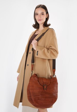 Sac à épaule en cuir brun avec une texture côtelée, une forme incurvée et une sangle ajustable, doté d'une fermeture à cliquet en métal.