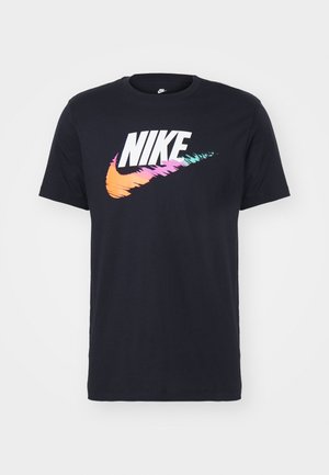 T-shirt en coton marine arborant un bold logo Nike blanc avec un design de swoosh multicolore en rose, orange et bleu-vert. Manches courtes, col ras du cou.