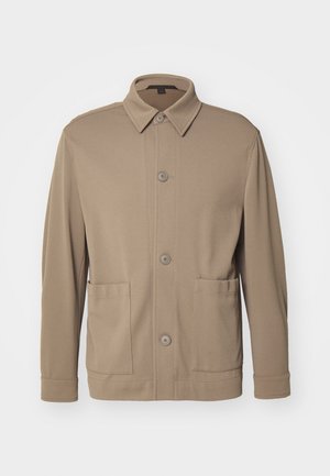 Veste cintrée à boutons beige en tissu texturé, avec un col, des boutons à l'avant et deux poches latérales. Design décontracté et ajusté.