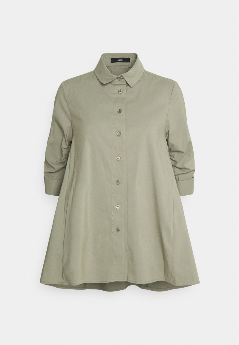 Light olive green shirt made of smooth fabric, featuring a collar, button front, and three-quarter sleeves with rolled cuffs.