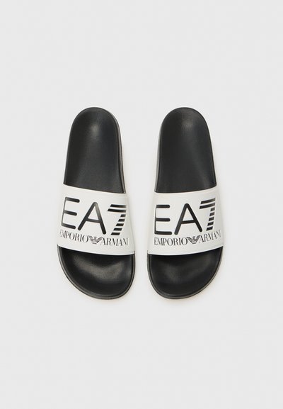 Черен слайд сандал с бялата лента, на която е изписано логото "EA7 EMPORIO ARMANI" с дебел черен шрифт. Гладък материал и плосък дизайн.