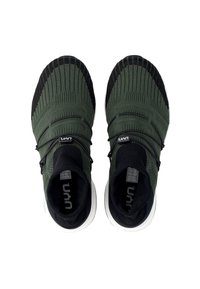 Green knit sneakers with black accents. Features a slip-on design, elastic laces, and white soles. Textured upper with breathable material.