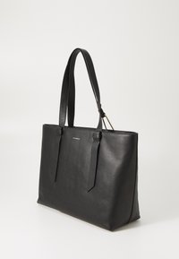 Black leather tote bag with a textured finish, two long handles, and a subtle logo. Features a structured shape and open top design.