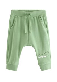 Πράσινο βαμβακερό παντελόνι φόρμας με ελαστική μέση, τσέπες και σχέδιο κροκόδειλου με λευκές λεπτομέρειες στο πόδι. Μαλακή υφή, χαλαρή εφαρμογή.