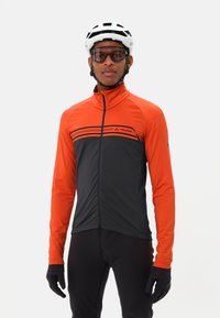 Veste de cyclisme avec un haut orange et un bas gris foncé, ornée de rayures horizontales et d'un col haut. Texture du tissu lisse.