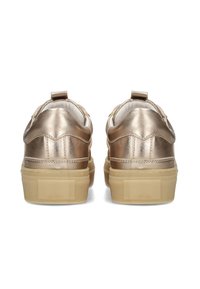 Zapatillas metálicas doradas con suela plana de goma, con un trasero texturizado y una pestaña para facilitar su uso. Material suave con detalles de costura.