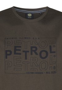 Olivově zelené bavlněné tričko s výrazným tmavě modrým logem a textem "PETROL", kulatým výstřihem, krátkými rukávy a hladkou texturou.