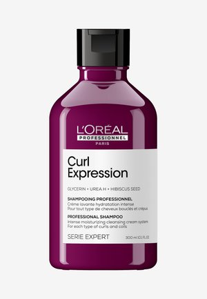 Bouteille en plastique violet de shampooing L'Oréal Curl Expression, avec un capuchon noir et une étiquette blanche avec texte noir. Capacité de 300 ml.