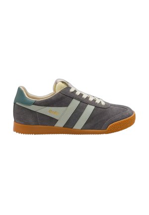 Zapatilla deportiva de ante gris con rayas blancas, talón azul claro, cordones blancos y suela de goma marrón texturizada, vista lateral.
