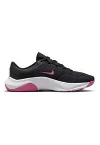 Chaussures de sport noires avec tige en maille, logo Nike rose, semelle intermédiaire blanche et semelle en caoutchouc rose avec grip texturé.