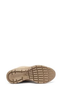 Suela de zapato de ante beige con una parte inferior de goma texturizada, que presenta un diseño de banda de rodadura con patrón para mayor agarre, y un logo grabado en el talón.