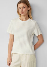 Cremefarbendes T-Shirt mit dezenten hellgelben Streifen, rundem Ausschnitt und kurzen Ärmeln. Weiches Material mit lockerer Passform.