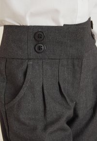 Grijze op maat gemaakte broek heeft een hoge tailleband met twee zwarte knopen, geplooide voorkant en zijzakken, gemaakt van een gestructureerde stof.